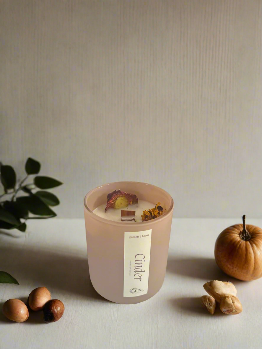 Pink candle with decorative elements on a neutral background